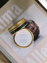 two gold travel candle tins styled on top of books